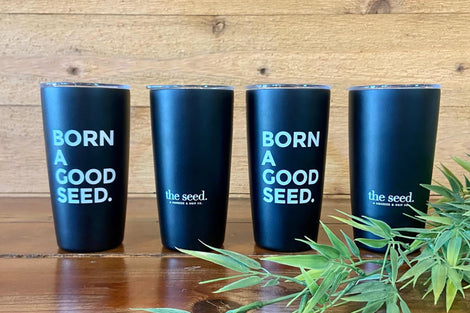 Photo of four reusable Miir tumblers lined up that say "Born a good seed."